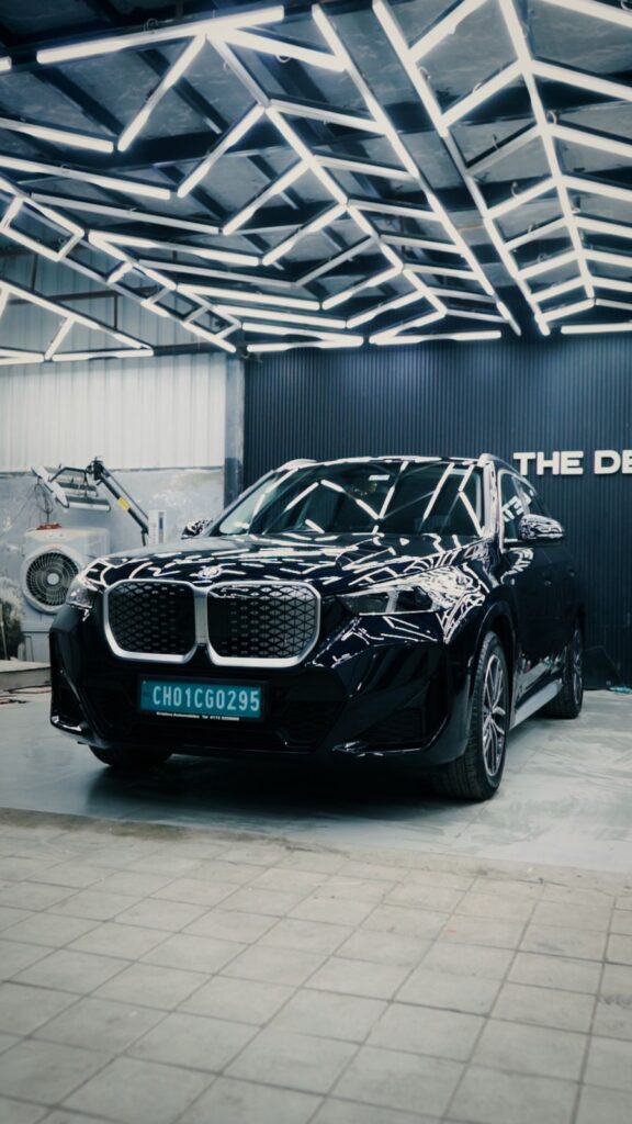 Luxury SUV professionally detailed under studio lighting at The Detailing Square, showcasing high-gloss paint finish and surface refinement.